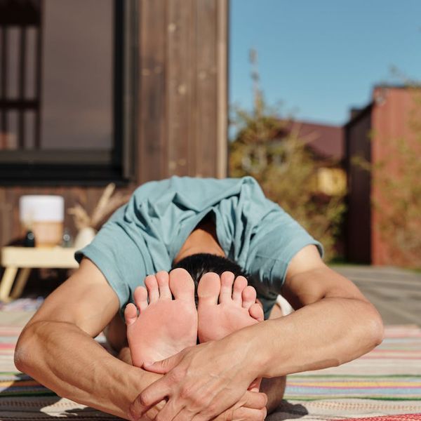 Person meditating peacefully after a workout session, sun shining through window.
